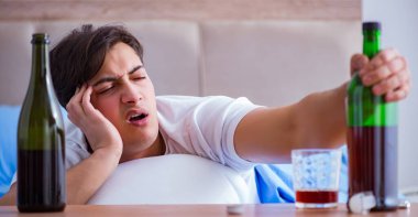 Yatakta içen alkolik adam depresyona giriyor.