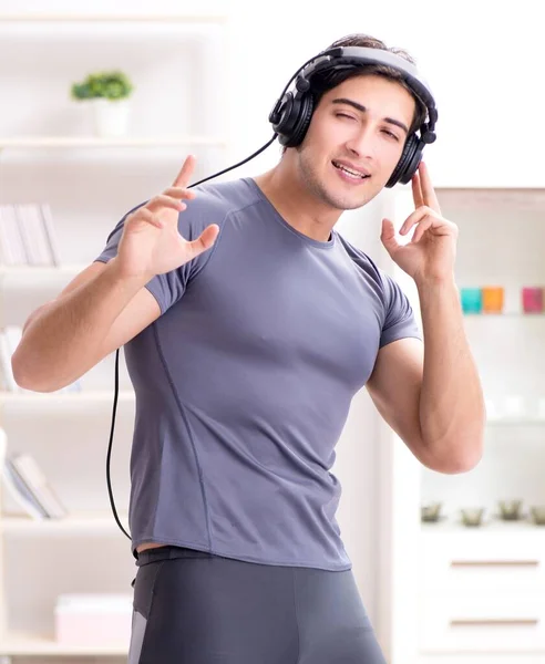 Hombre haciendo deportes en casa y escuchando música —  Fotos de Stock