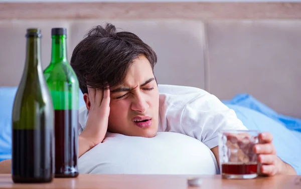 Hombre alcohólico bebiendo en la cama pasando por romper la depresión —  Fotos de Stock