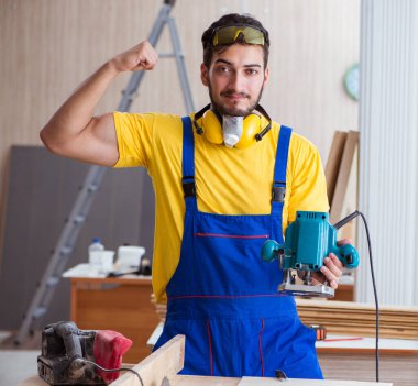 Elektrikli aletlerle çalışan genç marangoz.