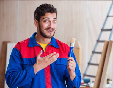 Yooung marangoz boyayla uğraşıyor.