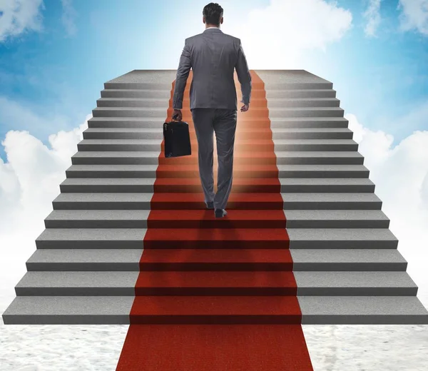 El joven empresario subiendo escaleras y alfombra roja en el cielo — Foto de Stock