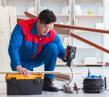 Genç marangoz ahşap kalaslarla çalışıyor.