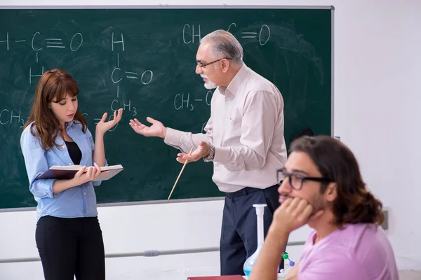 Starý učitel chemie a dva studenti ve třídě — Stock fotografie