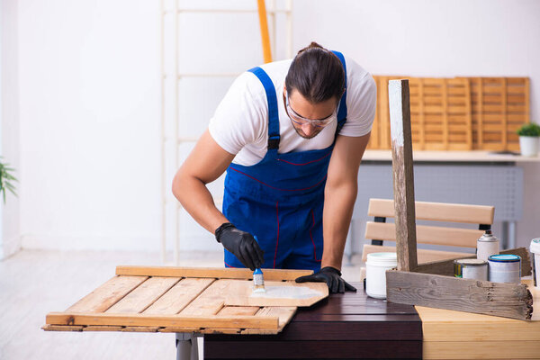 Young male contractor working in workshop