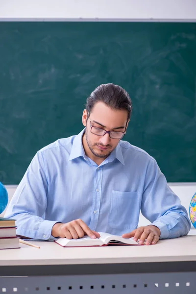 Young male geography teacher in front of blackboard — Stock Photo, Image