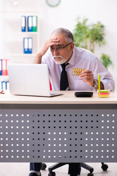 Gammal sjuk anställd som lider på arbetsplatsen — Stockfoto