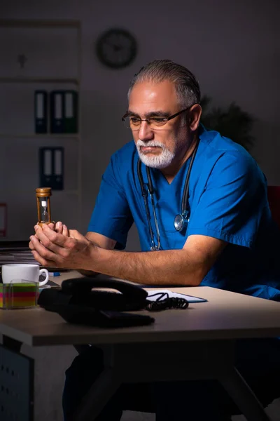 밤에 병원에 있는 나이든 남성 의사 — 스톡 사진