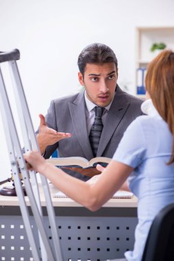 Yaralı genç kadın ve erkek avukat mahkeme salonunda.