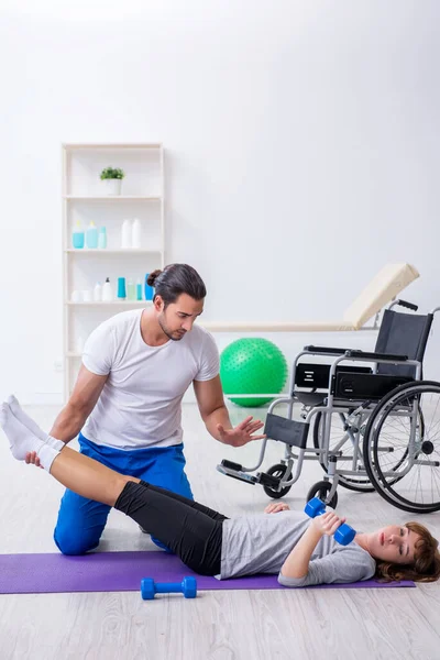 Woman in wheel-chair doing sport exercises with personal coach — Stock Photo, Image