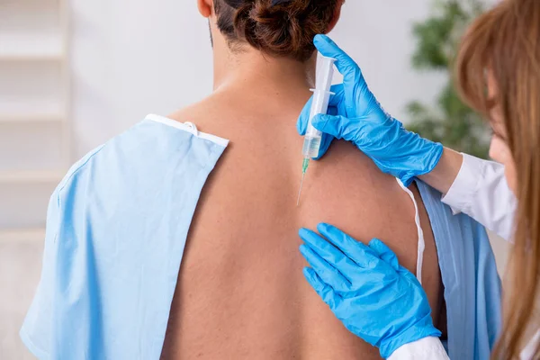 Jonge rug gewonde man op bezoek vrouwelijke arts chiropractor — Stockfoto