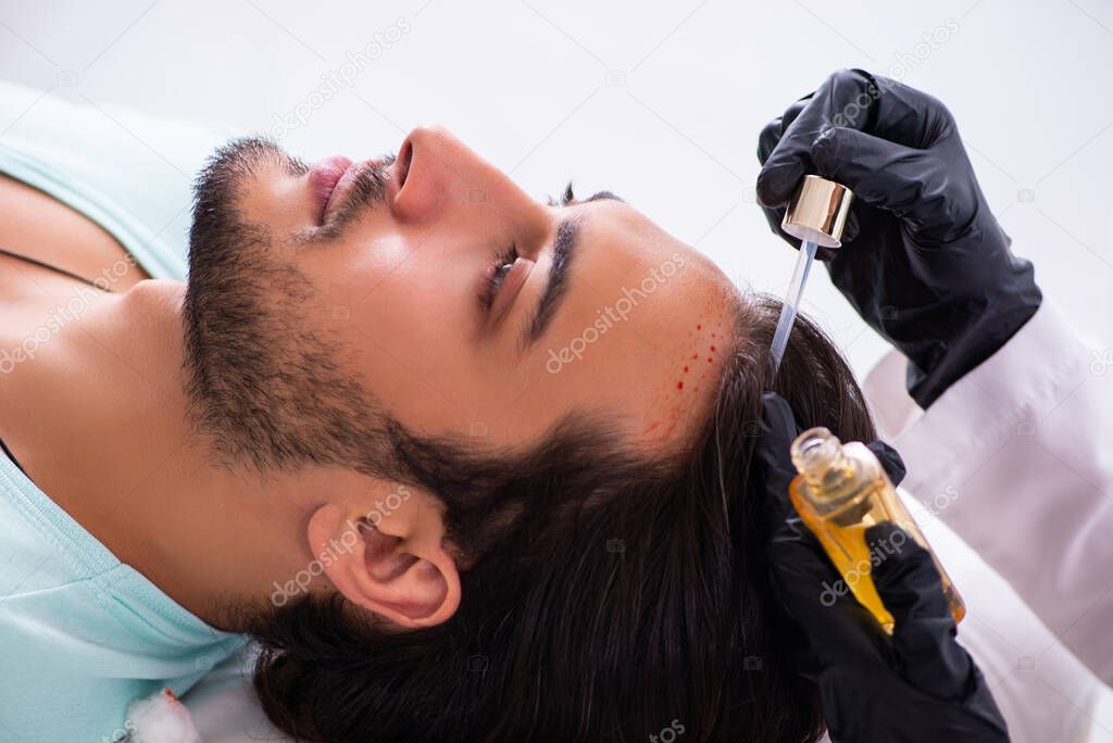 Young man visiting female beautician in hair transplantation con