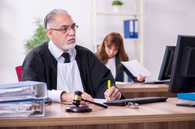 Yaşlı erkek yargıç ve genç sekreteri ofiste.