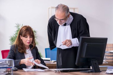 Yaşlı erkek yargıç ve genç sekreteri ofiste.