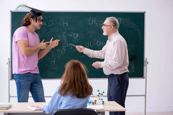 古い化学の先生と教室の2人の学生 — ストック写真