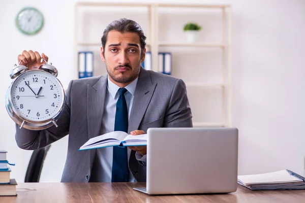 Jonge mannelijke zakenman die boeken leest op het werk — Stockfoto