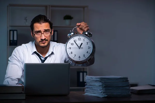 Jonge mannelijke werknemer die 's nachts op kantoor werkt — Stockfoto