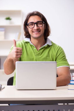 Sınıftaki genç erkek öğrenci.