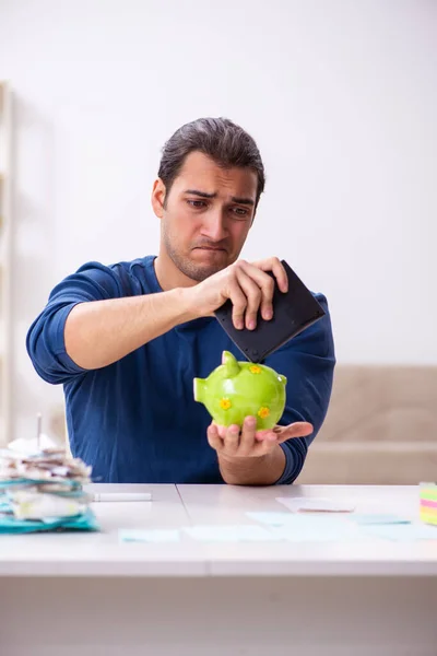 Jonge man in budget planning concept — Stockfoto