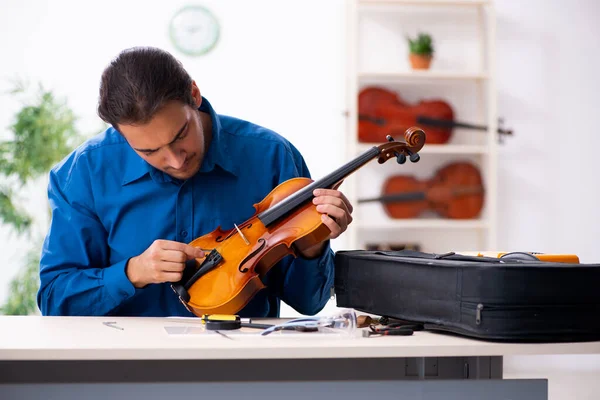 Hombre joven reparador reparando violín — Foto de Stock