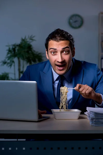 Funcionário com fome trabalhando até tarde no escritório — Fotografia de Stock