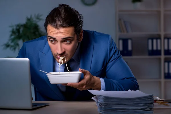 Funcionário com fome trabalhando até tarde no escritório — Fotografia de Stock