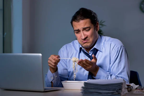 Funcionário com fome trabalhando até tarde no escritório — Fotografia de Stock