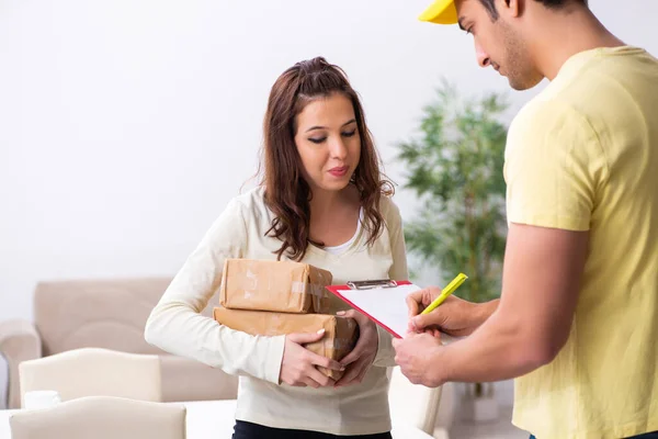 Junger männlicher Kurier bringt Paket ins Büro — Stockfoto