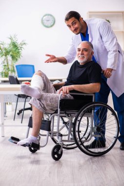 Yaşlı adam genç doktor travmatoloğu ziyaret ediyor.
