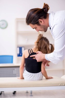 Küçük kız genç erkek doktoru ziyaret ediyor.