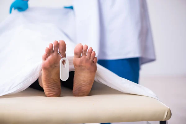 Police coroner examining dead body corpse in morgue — Stock Photo, Image