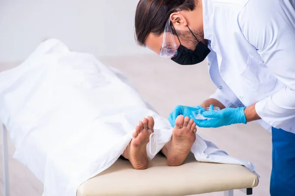 Police coroner examining dead body corpse in morgue — Stock Photo, Image