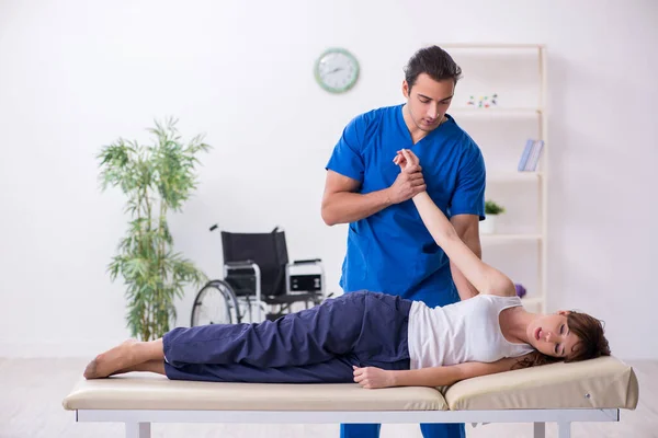 Injured woman visiting young male doctor osteopath — Stock Photo, Image