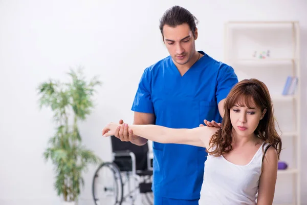 Mulher ferida visitando jovem médico osteopata — Fotografia de Stock