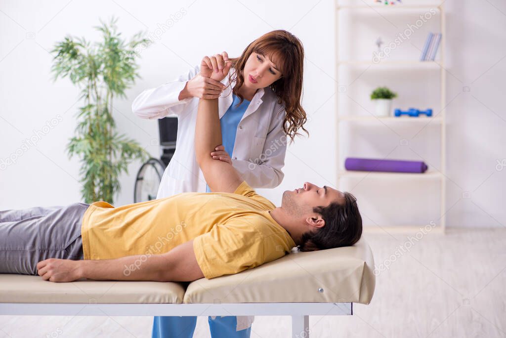 Injured man visiting young female doctor osteopath
