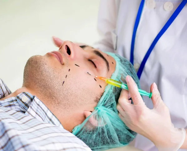 Chirurg plastyczny przygotowujący się do operacji twarzy człowieka — Zdjęcie stockowe