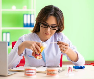 Diş implantı üzerinde çalışan kadın dişçi.