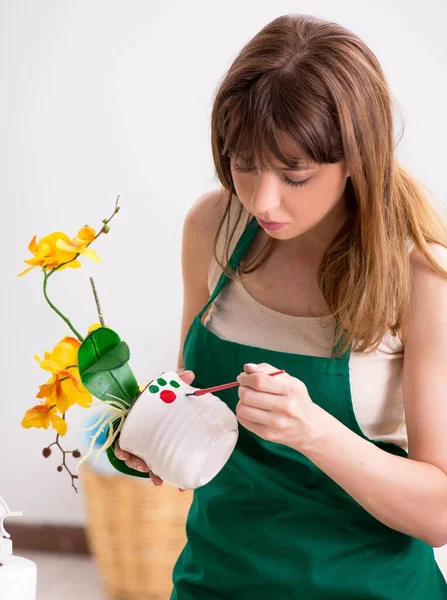 Jeune femme décoration poterie en atelier — Photo