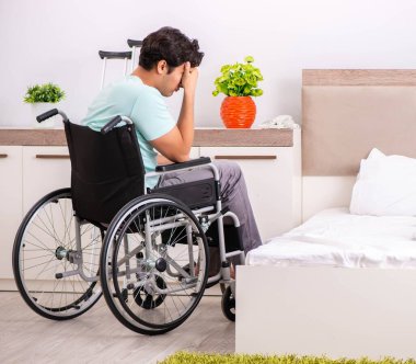 Genç yakışıklı engelli adam evde iyileşiyor.