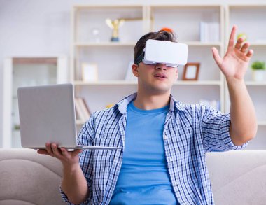 Evde sanal gerçeklik gözlükleriyle serbest çalışan bir öğrenci.