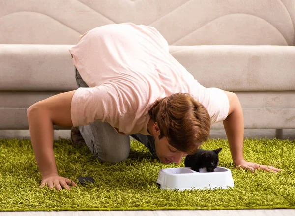 Jovem brincando com gatinho em casa — Fotografia de Stock