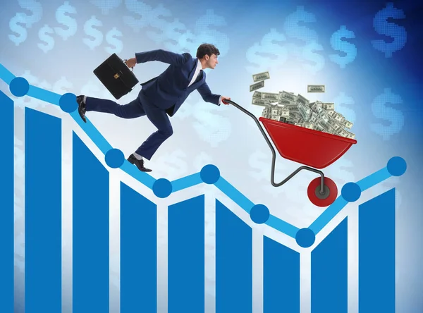 Businessman pushing money wheelbarrow down the chart — Stock Photo, Image