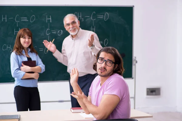 Old chemist teacher and two students in the classroom — Stock Photo, Image