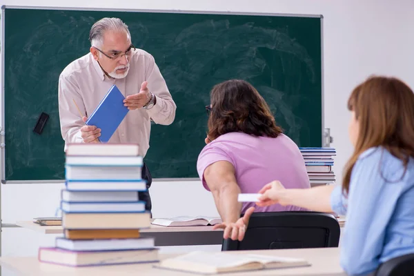 Oude scheikundeleraar en twee leerlingen in de klas — Stockfoto