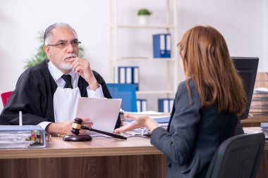 Yaşlı yargıç ve bayan müvekkil büroda.