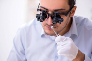 Genç erkek kuyumcu atölyede.