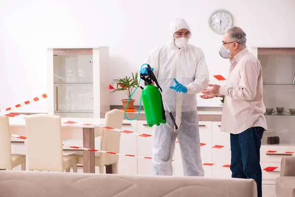 Young male sanitizer and old man indoors — Stock Photo, Image