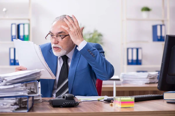 Velho empregado masculino e excesso de trabalho no escritório — Fotografia de Stock