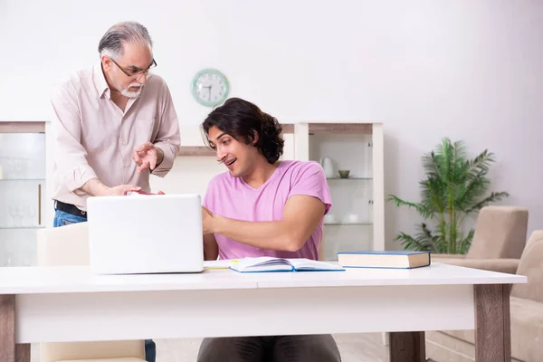 Alter Vater hilft seinem Sohn bei der Prüfungsvorbereitung — Stockfoto