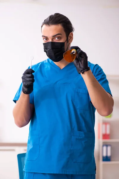 Klinikte çalışan genç erkek dişçi. — Stok fotoğraf